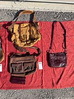 Photo of three shoulder bags including a large tan canvas satchel, a dark brown leather satchel, and a smaller dark burgundy leather shoulder bag.