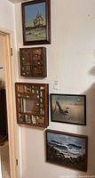 Wall display showing three framed paintings and two wooden cabinets containing miniatures