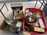 Overview of all boxes including cardboard boxes and red plastic bin with visible Christmas decorations and miscellaneous items inside