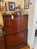 Full view of Dixie wooden dresser against a wall with decorative items on top.