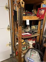 Photo of Shop Vac and assorted tools on wood shelving, including hand planes and sanding block