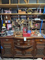 Full view of carved wooden sideboard with tools on top