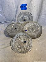Stack of 18 clear glass plates with intricate Cape Cod pattern and original blue Imperial Glass stickers on most plates.