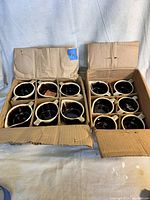 18 vintage Pfaltzgraff sugar and creamer pieces packed in two open and worn cardboard boxes with dividers.