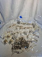 Photo showing large assortment of bracelets grouped into many plastic bags labeled with birth months and some unbagged.