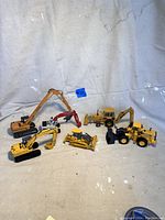 Wide shot showing all six construction vehicles arranged on a white backdrop for lot overview.