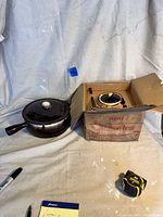 Soup tureen with lid inside original cardboard box beside casserole, showing packaging and set contents