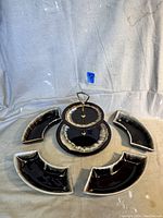 Photo showing 2-tier tray with metal handle and four matching curved dishes around it, all featuring brown drip glaze with beige speckled edges.