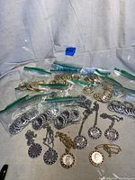Full view of all bezels in sealed bags and displayed pendants with silver dollar coins.