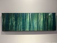 Full view of bamboo forest photo on canvas print mounted on wall, showing size and framing.