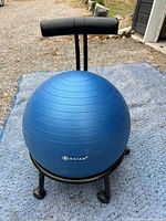 Front view of blue Gaiam exercise ball mounted on black frame with adjustable padded backrest and castors.