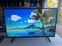 Front view of LG TV screen powered on showing a vibrant scenic display with a 'No Signal' message, indicating the TV is tested and working.