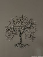 Full view of the black metal tree wall sculpture with crystal accents on branch tips.