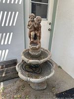 Full front view of entire fountain showing cherub figures, basins, and base