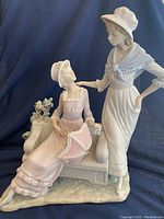 Front view showing seated and standing women with bench