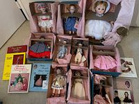 Group view of Madame Alexander dolls in original boxes with pink tissue, unboxed cloth doll, and five books