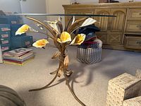 Glass top lily table with tole painted metal base featuring painted lily flowers in yellow and white.