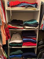 Four shelves of folded men's tops and bottoms showing assorted colors and styles