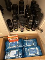 Multiple Tresemme hair styling products arranged on shelf, plus box of washcloths and Johnson’s foot soap