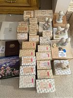 Collection of Precious Moments doll boxes arranged with some dolls displayed outside boxes on top.