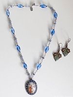 Full view necklace arranged in V with pendant and both earrings