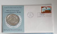 Medal sealed in presentation envelope with stamp and postmark