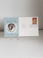 Front view of medal set in folder with first-day cover envelope and stamp