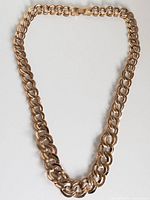 Full view of gold-tone double-link necklace laid flat