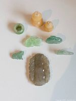 All eight jade carvings arranged with largest plaque in front, showing colors and forms