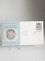 Full view of first day cover with medal and stamp
