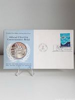 Front of folder showing medal set into cover with title, postmark, and stamp