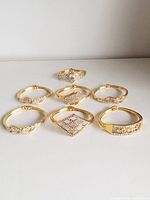 Seven gold-tone rhinestone bangles arranged on surface