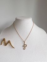 Brooch and necklace displayed on bust, front view