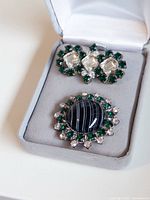 Both buttons inside jewelry box, showing design and scale