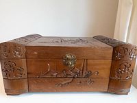 front view of carved jewelry box with dragon and floral motifs