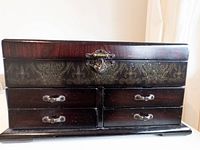 front view of dark wood jewelry box with clasp and drawers