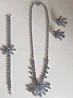 Necklace, bracelet, earrings full set laid flat