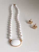 Full view of white bead Trifari necklace and butterfly clip-on earrings