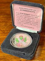 Coin and certificate displayed in black velveteen box with lid open