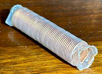 Full view of sealed clear plastic roll containing 50 Canadian 1 cent pennies.