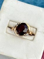 Top view of oval garnet and diamond ring in 10k yellow gold