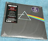 Front cover of 2016 Pink Floyd Dark Side of the Moon vinyl LP sealed in shrink wrap showing iconic prism and rainbow light refracting design with hype sticker.
