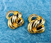 Front view of both earrings on blue background