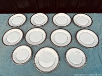 Overhead view of 11 bone china plates in Sarabande pattern arranged in rows