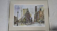 Framed lithograph print of the Flat Iron Building in Toronto with cityscape, signed by Gerard Paraghamian, visible details of signature, numbering, and print quality.