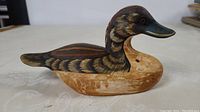 Side angle of the hand carved painted wooden duck showing detailed feather patterns and paint wear