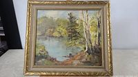 Full view of the oil on board lake scene painting in gold Hamilton frame.
