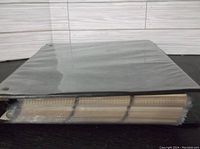 Black 3-ring binder thick with baseball trading card pages inside, spine and pages visible.