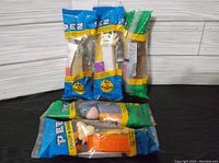 Photo showing five PEZ candy dispensers in original sealed packaging featuring Star Wars and Winnie the Pooh characters