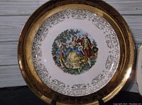 Close-up of a 7-inch Early American By Harker decorative plate showing central figurative design and gold ornate border